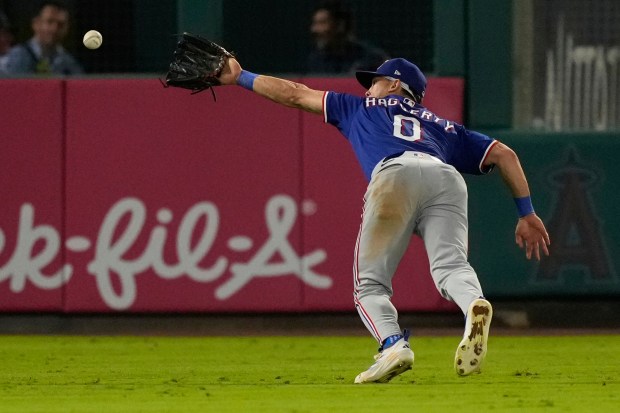 Texas Rangers left fielder Sam Haggerty can’t handle a ball...