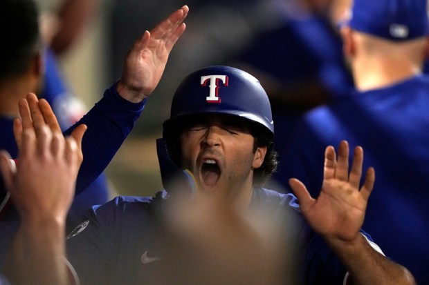 The Texas Rangers’ Josh Smith is congratulated by teammates in...