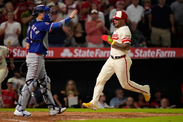The Angels’ Yoan Moncada, right, scores on a double by...