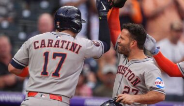 Houston Astros' Jose Altuve, right, congratulates Victor Caratini after his grand slam off Colorado Rockies starting pitcher Chase Dollander in the third inning of a baseball game Tuesday, July 1, 2025, in Denver. (AP Photo/David Zalubowski)