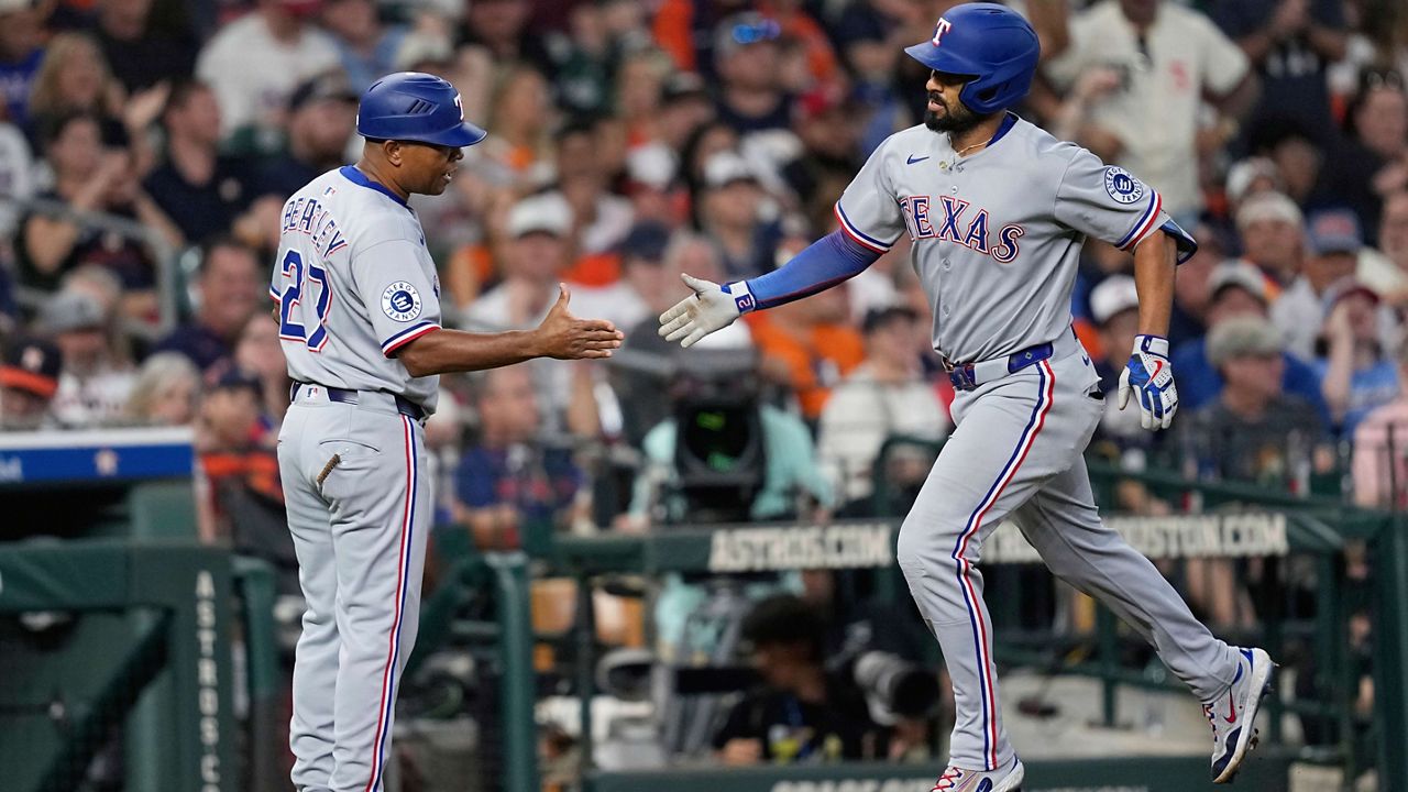 Texas Rangers' Marcus Semien, right, celebrates with third base coach Tony Beasley after hitting a home run against the Houston Astros during the eighth inning of a baseball game Sunday, July 13, 2025, in Houston. (AP Photo/David J. Phillip)