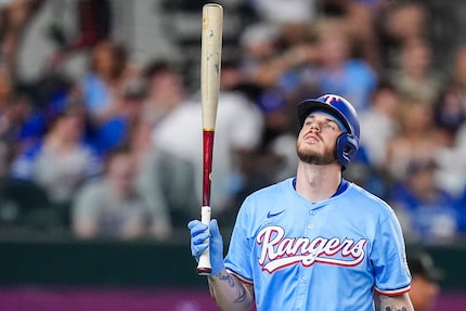 Texas Rangers catcher Jonah Heim reacts after striking out with runners in scoring position...