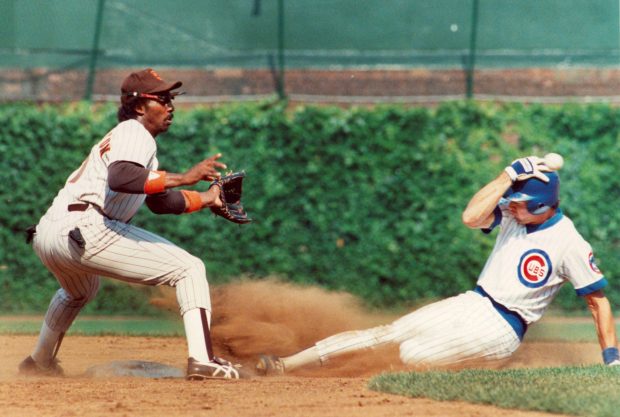 The Cubs' Ryne Sandberg, stealing second base, protects his head from a wild throw by San Diego catcher Bruce Bochy as second baseman Garry Templeton awaits the throw on July 9, 1985. (Ed Wagner Jr./Chicago Tribune)