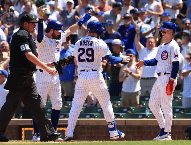 Cubs first baseman Michael Busch is congratulated after hitting a three-run home run against the Mariners in the third inning on June 21, 2025, at Wrigley Field. (John J. Kim/Chicago Tribune)