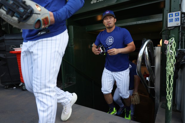Cubs designated hitter Seiya Suzuki, right, exits the clubhouse to warm up for a game against the Red Sox on July 19, 2025, at Wrigley Field. (John J. Kim/Chicago Tribune)