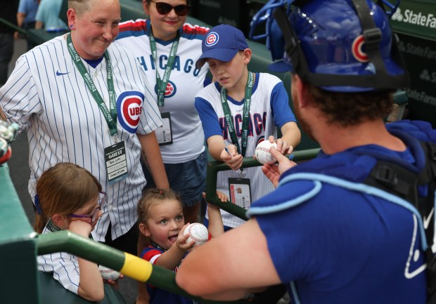 Young fans get autographs from Cubs catcher Carson Kelly before a game against the Red Sox on July 19, 2025, at Wrigley Field. (John J. Kim/Chicago Tribune)