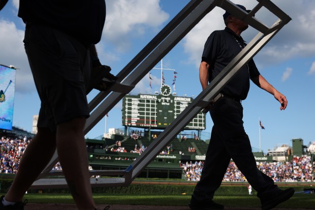 Grounds-crew workers bring the batter's box to home plate in preparation for a Cubs-Red Sox game on July 19, 2025, at Wrigley Field. (John J. Kim/Chicago Tribune)