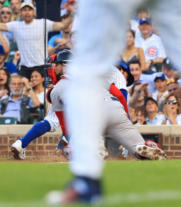 Cubs shortstop Dansby Swanson, right, beats the tag from Red Sox catcher Connor Wong to score on a sacrifice fly in the second inning on July 19, 2025, at Wrigley Field. (John J. Kim/Chicago Tribune)