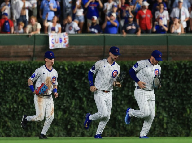 Cubs center fielder Pete Crow-Armstrong, from left, right fielder Kyle Tucker and left fielder Ian Happ head in after a 6-0 win over the Red Sox on July 19, 2025, at Wrigley Field. (John J. Kim/Chicago Tribune)