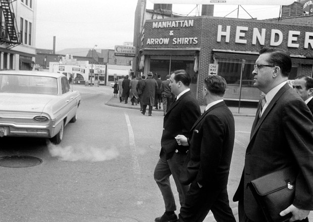 Teamsters President James Hoffa turns his head on Jan. 15, 1964, and watches the jury walk down the street during recess in Chicago. With Hoffa is aide Charles O'Brien. Hoffa was on trial with five co-defendants for jury tampering. (AP)