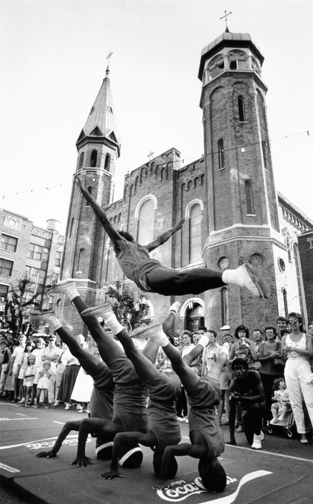 Members of the Jesse White Tumblers help get festivities started at the "World's Largest Block Party" on July 25, 1986, outside Old St. Patrick's Church at Adams and Desplaines streets in Chicago. The neighborhood get-together was held to commemorate the 140th anniversary of the church. (David Butow/Chicago Tribune)