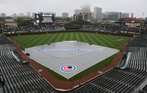 The rain tarp covers the infield before a Cubs-Cardinals game at Wrigley Field on July 6, 2025, in Chicago. (John J. Kim/Chicago Tribune)