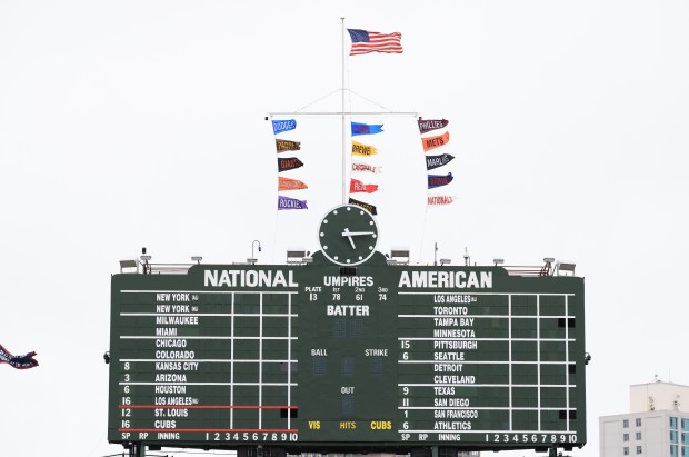 National League standings banners flap in the wind above the scoreboard before a Cubs-Cardinals game at Wrigley Field on July 6, 2025, in Chicago. (John J. Kim/Chicago Tribune)