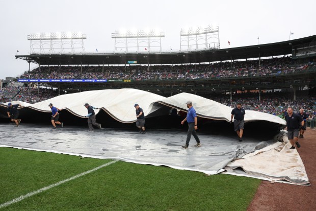 The rain tarp comes off for a Cubs-Cardinals game at Wrigley Field on July 6, 2025, in Chicago. (John J. Kim/Chicago Tribune)