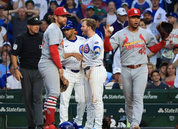Cubs left fielder Ian Happ, center, argues with first base umpire Adam Hamari, left, after being called on a groundout in the third inning against the Cardinals at Wrigley Field on July 6, 2025, in Chicago. (John J. Kim/Chicago Tribune)
