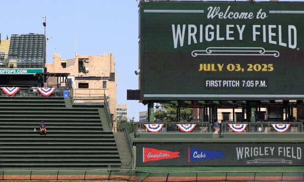 A guest services worker sits alone in the right-field bleachers before a Cubs-Guardians game at Wrigley Field on July 3, 2025, in Chicago. (John J. Kim/Chicago Tribune)