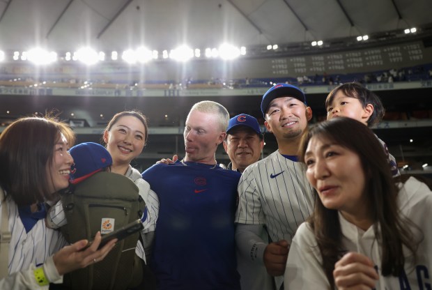Cubs center fielder Pete Crow-Armstrong, center, makes a face at...