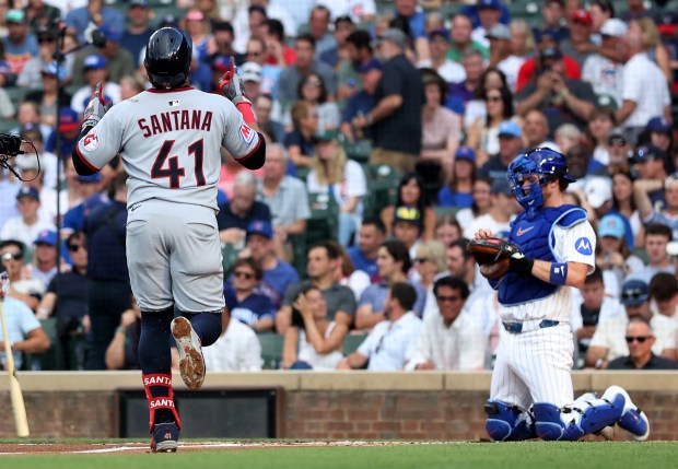 Cleveland Guardians first baseman Carlos Santana (41) passes by Chicago Cubs catcher Carson Kelly as Santana crosses home plate after hitting a solo home run in the second inning of a game at Wrigley Field in Chicago on July 2, 2025. (Chris Sweda/Chicago Tribune)