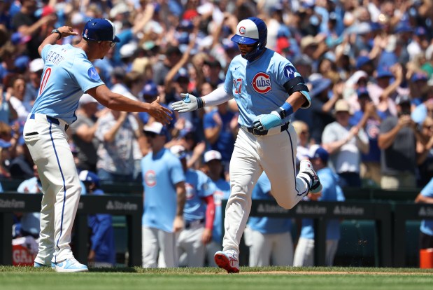 Cubs designated hitter Seiya Suzuki, right, slaps hands with third-base coach Quintin Berry after hitting a three-run home run in the first inning against the Red Sox on July 18, 2025, at Wrigley Field. (Chris Sweda/Chicago Tribune)
