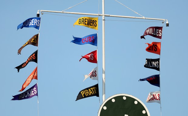 Flags atop the Wrigley Field scoreboard show the Milwaukee Brewers in first place ahead of the Chicago Cubs in the National League Central before a game between the Kansas City Royals in Chicago on July 22, 2025. (Chris Sweda/Chicago Tribune)