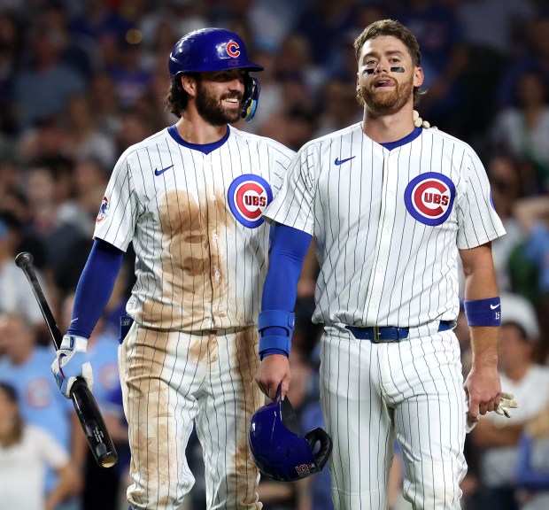 Chicago Cubs shortstop Dansby Swanson (left) has a laugh with teammate Carson Kelly after Kelly scored a run on a double by Pete Crow-Armstrong in the fifth inning of a game against the Kansas City Royals at Wrigley Field in Chicago on July 22, 2025. (Chris Sweda/Chicago Tribune)