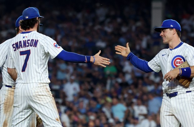 Chicago Cubs third baseman Matt Shaw (right) congratulates teammate Dansby Swanson (7) after the Cubs shortstop made a nice play to complete an inning-ending double play in the fifth inning of a game against the Kansas City Royals at Wrigley Field in Chicago on July 22, 2025. (Chris Sweda/Chicago Tribune)