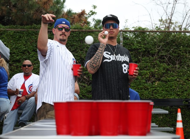 Cubs fan Andrew Schuffert, left, and White Sox fan Jose Botello play a drinking game while tailgating before a White Sox-Cubs game on July 25, 2025, at Rate Field. (John J. Kim/Chicago Tribune)