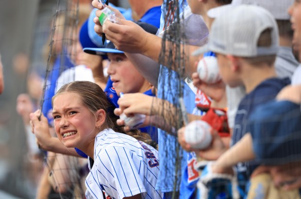 A young fan grimaces as she is pushed while seeking autographs before a White Sox-Cubs game on July 25, 2025, at Rate Field. (John J. Kim/Chicago Tribune)