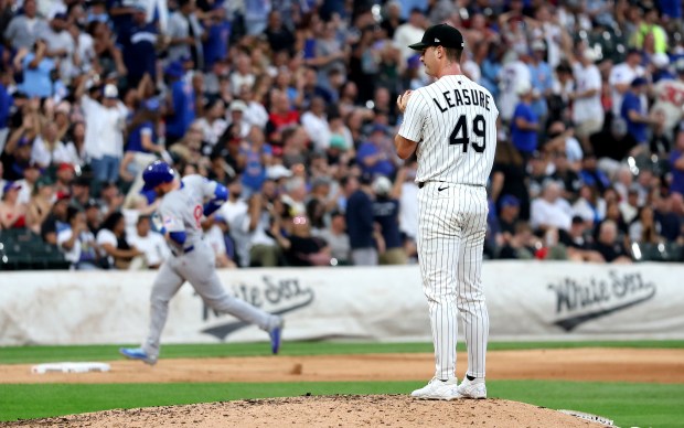 White Sox reliever Jordan Leasure stands on the mound as Cubs left fielder Ian Happ, background, rounds the bases after hitting a solo home run in the seventh inning on July 26, 2025, at Rate Field. (Chris Sweda/Chicago Tribune)
