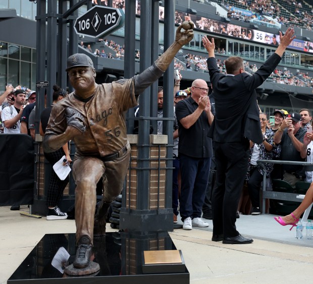 White Sox great Mark Buehrle waves to the crowd while standing with a new bronze statue of him that was unveiled at Rate Field, July 11, 2025. (Chris Sweda/Chicago Tribune)