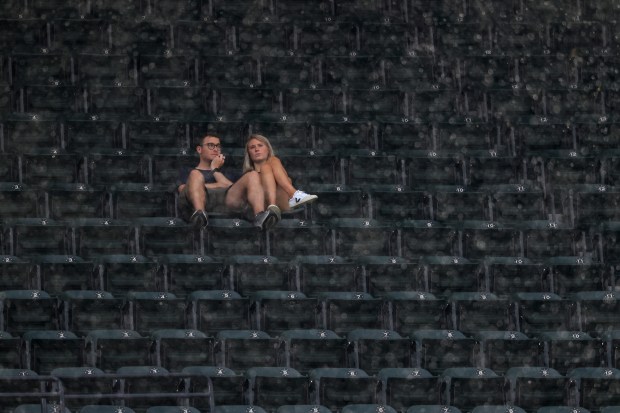 Two fans sit in their seats in the upper deck during a rain delay for a White Sox-Phillies game at Rate Field on July 30, 2025, in Chicago. (John J. Kim/Chicago Tribune)