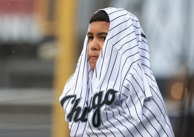 A young fan covers himself from the rain with a jersey during a rain delay for a White Sox-Phillies game on July 30, 2025, in Chicago. (John J. Kim/Chicago Tribune) (John J. Kim/Chicago Tribune)