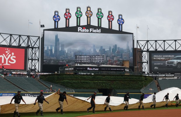Grounds crew workers take off the rain tarp for a White Sox-Phillies game at Rate Field on July 30, 2025, in Chicago. (John J. Kim/Chicago Tribune)