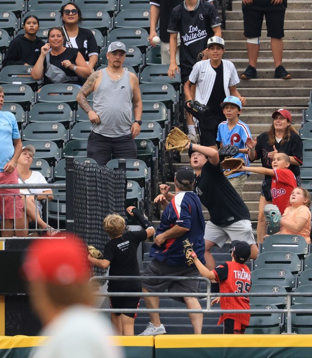 Fans aim to catch a three-run home run ball hit by White Sox first baseman Miguel Vargas in the seventh inning against the Phillies at Rate Field on July 30, 2025, in Chicago. (John J. Kim/Chicago Tribune)