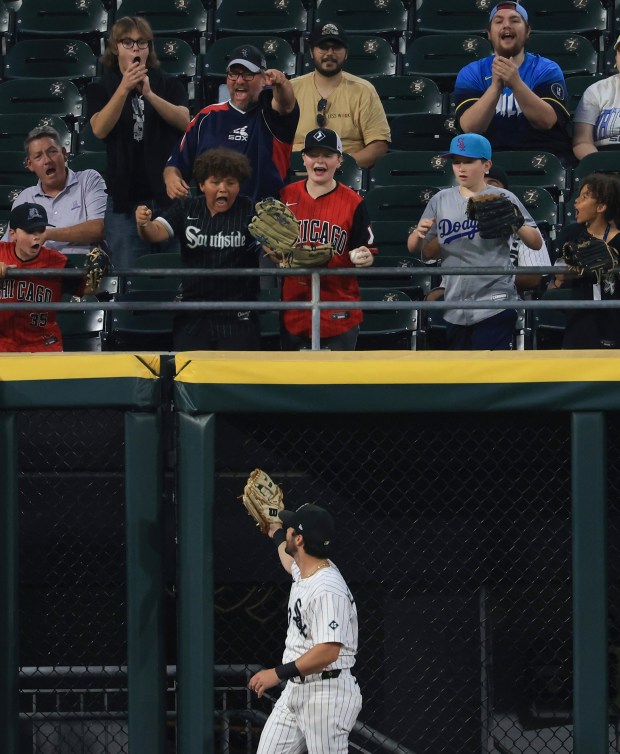 Excited fans cheer for White Sox left fielder Andrew Benintendi after catching what would have been a home run ball by Phillies first baseman Bryce Harper for an out in the eighth inning at Rate Field on July 30, 2025, in Chicago. (John J. Kim/Chicago Tribune)