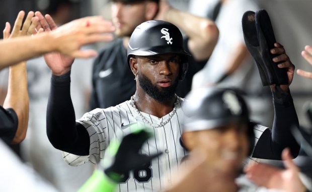 Chicago White Sox center fielder Luis Robert Jr. is congratulated by his teammates in the dugout after scoring on a two-run home run by teammate Lenyn Sosa in the ninth inning of a game against the Philadelphia Phillies at Rate Field in Chicago on July 29, 2025. (Chris Sweda/Chicago Tribune)
