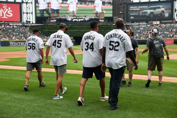 Former Chicago White Sox pitchers José Contreras, from right, Freddy García, Jon Garland (wearing a Bobby Jenks jersey), and Mark Buehrle walk to the mound to throw out the first pitch together before the game against the Cleveland Guardians at Rate Field on Sunday, July 13, 2025. (Eileen T. Meslar/Chicago Tribune)