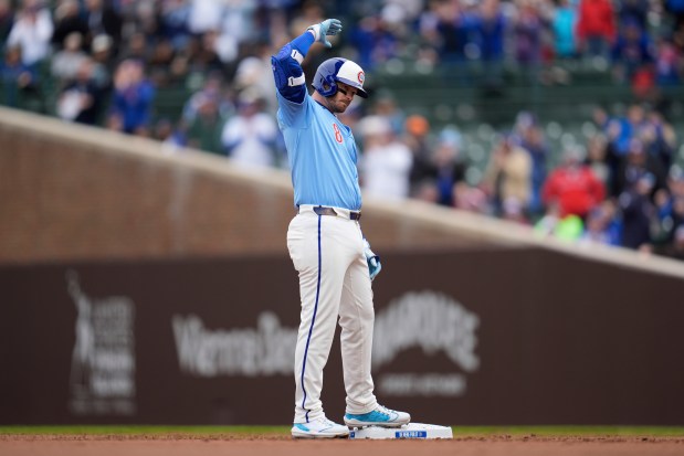 Cubs left fielder Ian Happ signals to the dugout after hitting a double in the first inning against the Padres on April 5, 2025, at Wrigley Field. (Erin Hooley/AP)
