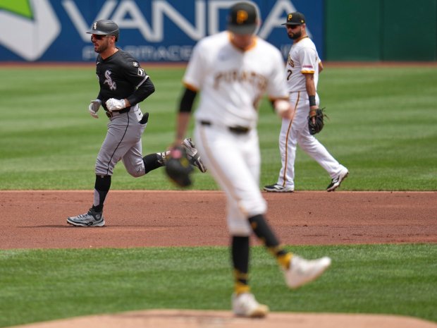 Chicago White Sox's Mike Tauchman, left, rounds the bases after hitting a solo home run off Pittsburgh Pirates pitcher Andrew Heaney, center, during the first inning of a baseball game in Pittsburgh, Sunday, July 20, 2025. (AP Photo/Gene J. Puskar)