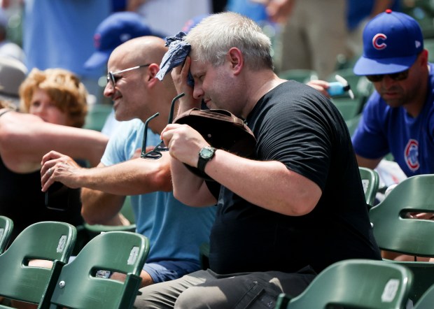 A fan wipes his face before the Cubs host the Royals at Wrigley Field, July 23, 2025. (Eileen T. Meslar/Chicago Tribune)