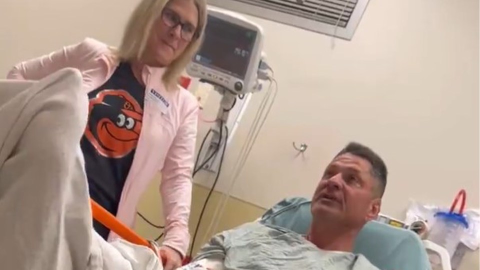 Man in hospital bed with woman.