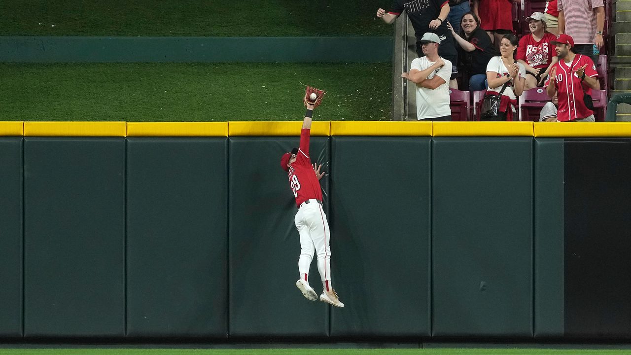 Cincinnati Reds' TJ Friedl catches a fly ball at the wall to end the game in the ninth inning of a baseball game against the Milwaukee Brewers, Tuesday, June 3, 2025, in Cincinnati. (AP Photo/Kareem Elgazzar)