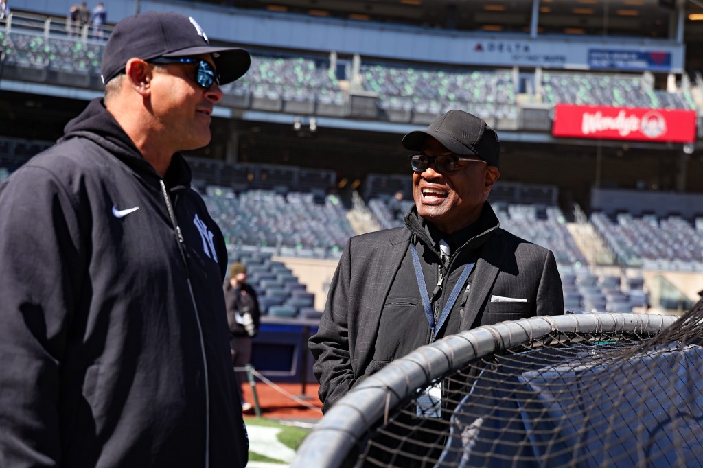 Yankees radio announcer Dave Sims (r.) talks to manager Aaron Boone (l.)
