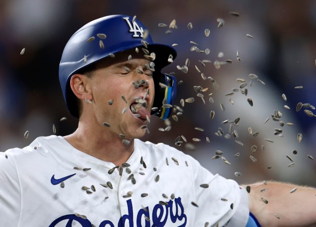 The Dodgers’ Will Smith is showered with sunflower seeds as...