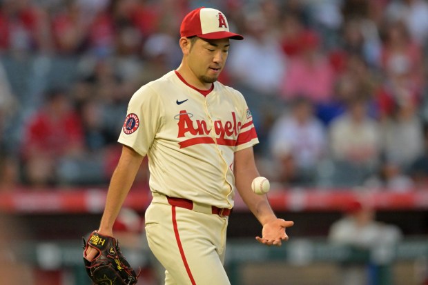 Angels starting pitcher Yusei Kikuchi tosses a new baseball after...