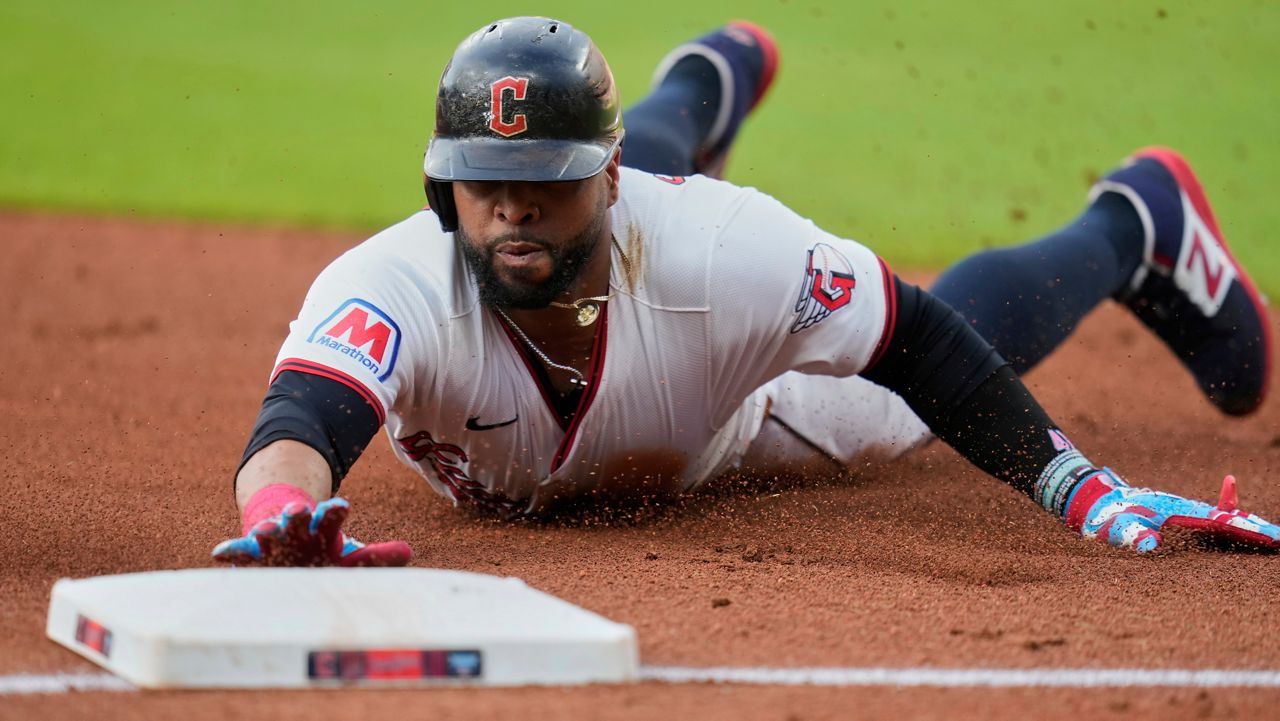 Cleveland Guardians' Carlos Santana slides safely into third base on a hit by Lane Thomas in the first inning of a baseball game against the Detroit Tigers in Cleveland, Friday, July 4, 2025.