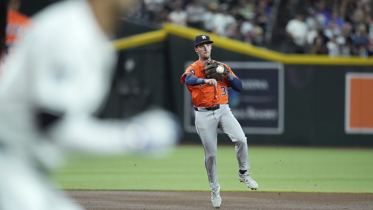 Houston Astros shortstop Zack Short, right, throws to first base to get Arizona Diamondbacks' Lourdes Gurriel Jr. out during the first inning of a baseball game Tuesday, July 22, 2025, in Phoenix. (AP Photo/Ross D. Franklin)