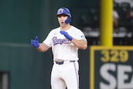Texas Rangers Wyatt Langford cheers scoring a double during the seventh inning of a baseball...