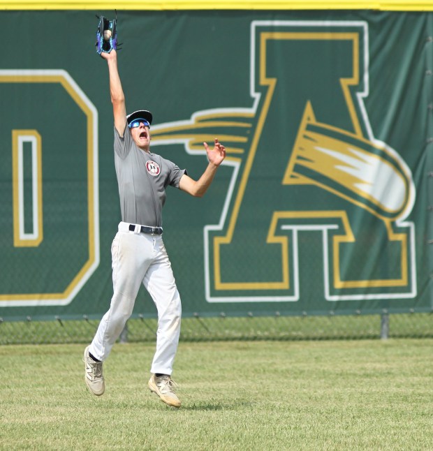 The Rocky River left fielder reaches up to make a...