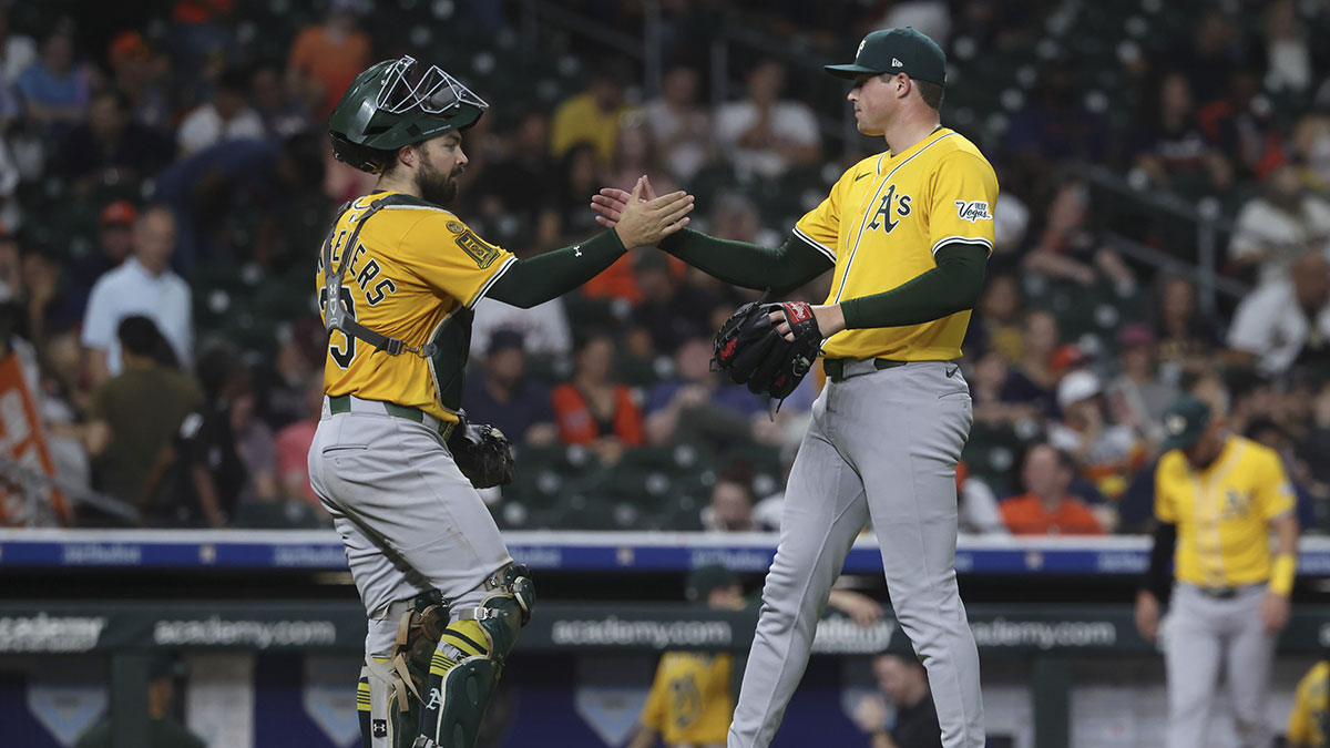 Athletics pitcher Mason Miller (19) celebrates with catcher Shea Langeliers (23) after the game against the Houston Astros at Daikin Park.